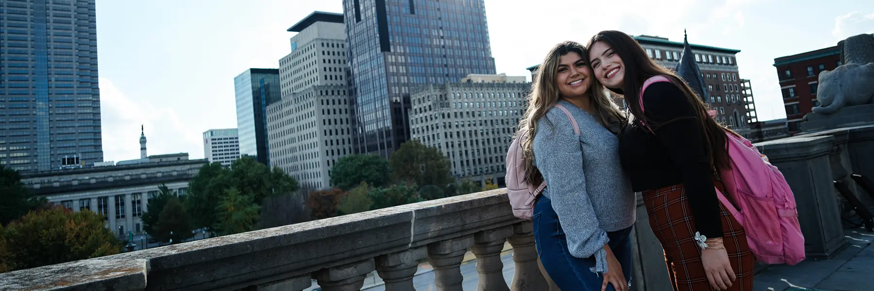 Two female students pose on a patio overlooking downtown Indianapolis