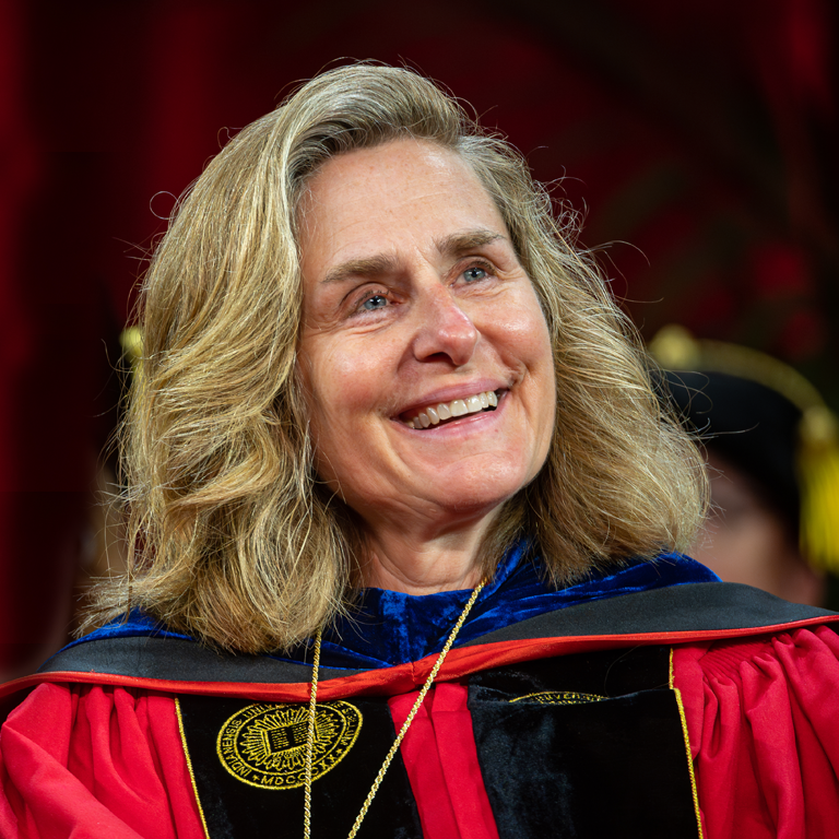 President Pam Whitten smiles, wearing commencement robes during the Freshman Induction ceremony